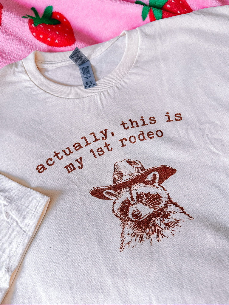 A natural t-shirt with a raccoon printed on it
