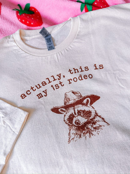 A natural t-shirt with a raccoon printed on it